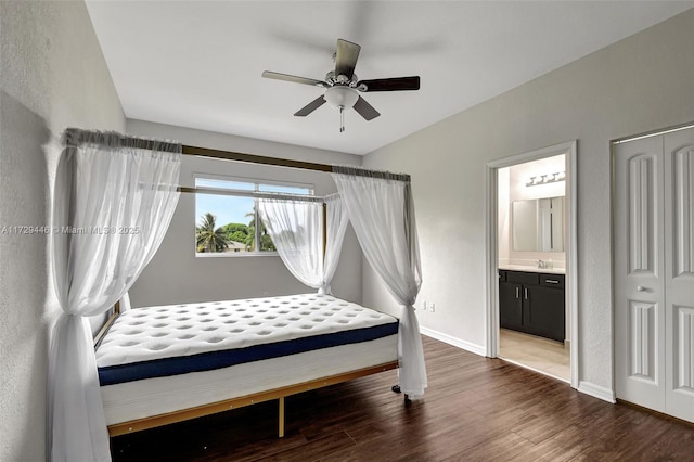 bedroom with connected bathroom, dark hardwood / wood-style flooring, sink, a closet, and ceiling fan