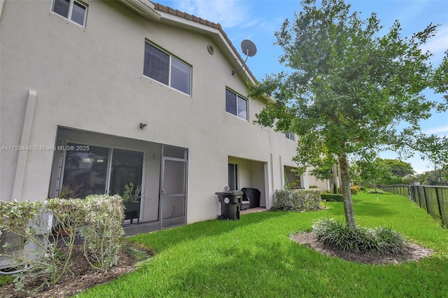 rear view of house featuring a yard