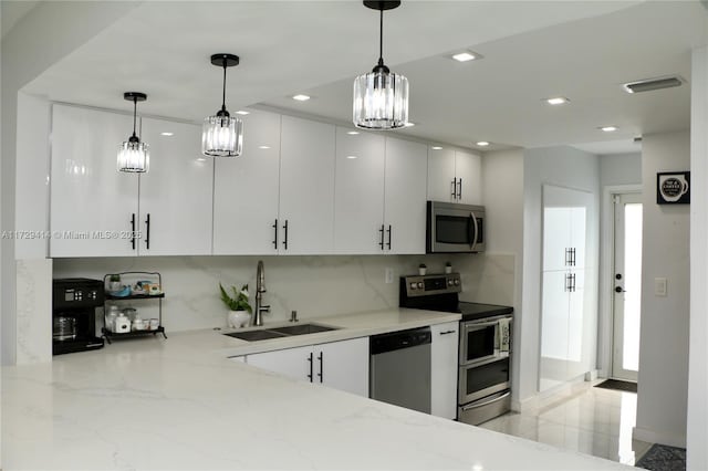 kitchen featuring pendant lighting, sink, white cabinetry, and stainless steel appliances