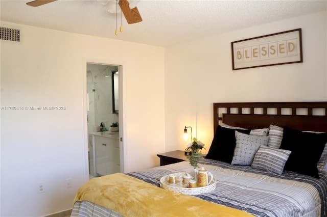 bedroom with a textured ceiling, ceiling fan, and ensuite bathroom