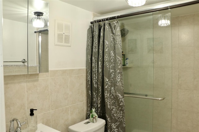 bathroom featuring tile walls, toilet, and walk in shower