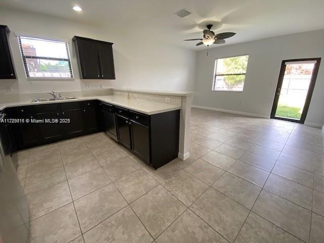 kitchen with ceiling fan, light tile patterned flooring, kitchen peninsula, and sink