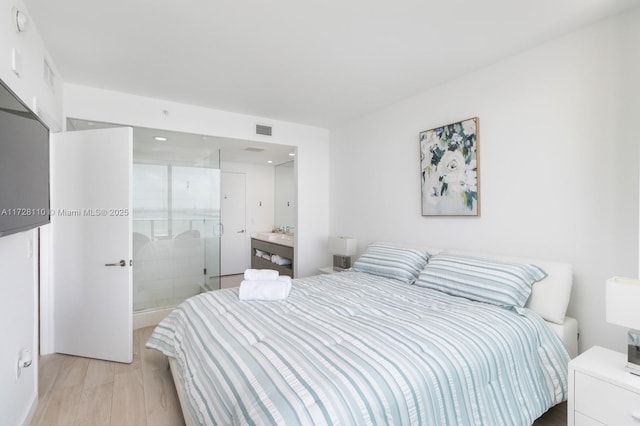 bedroom with light wood-type flooring and sink