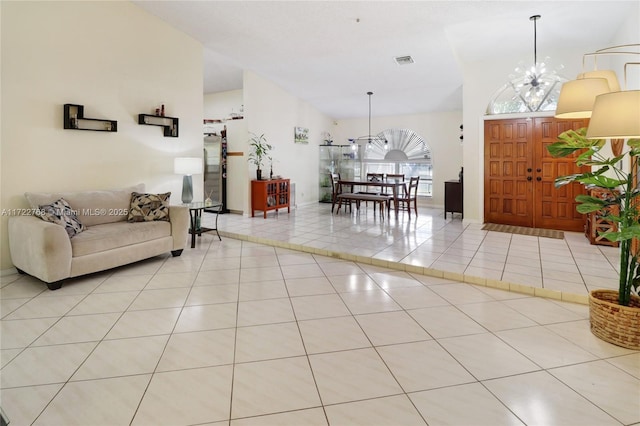 entrance foyer with a towering ceiling, light tile patterned floors, and a notable chandelier