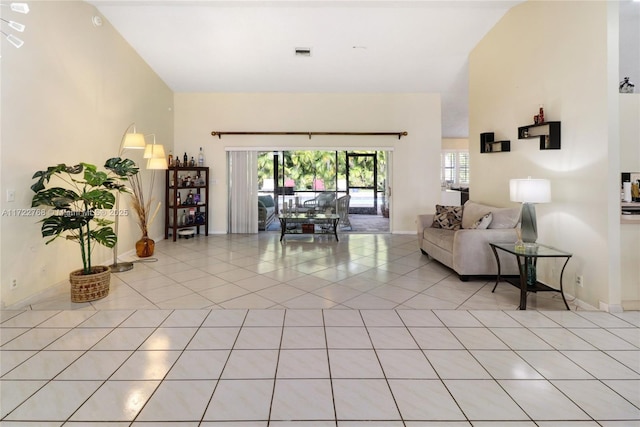 living room with lofted ceiling and light tile patterned floors