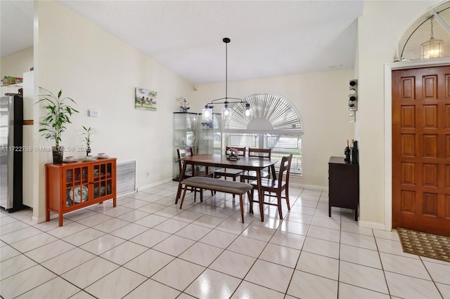 dining area with lofted ceiling and light tile patterned flooring