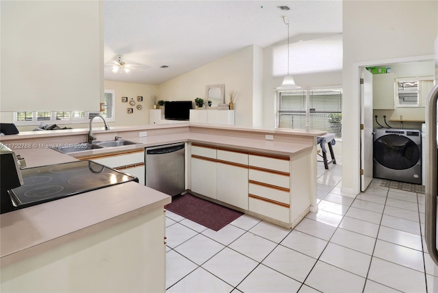 kitchen featuring washer / dryer, kitchen peninsula, stainless steel appliances, decorative light fixtures, and lofted ceiling