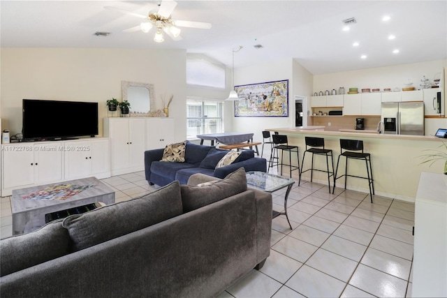 tiled living room with ceiling fan and high vaulted ceiling