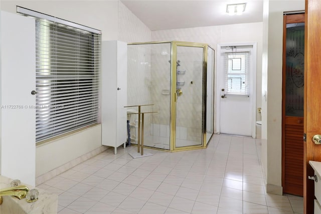 bathroom with a shower with door and tile patterned flooring