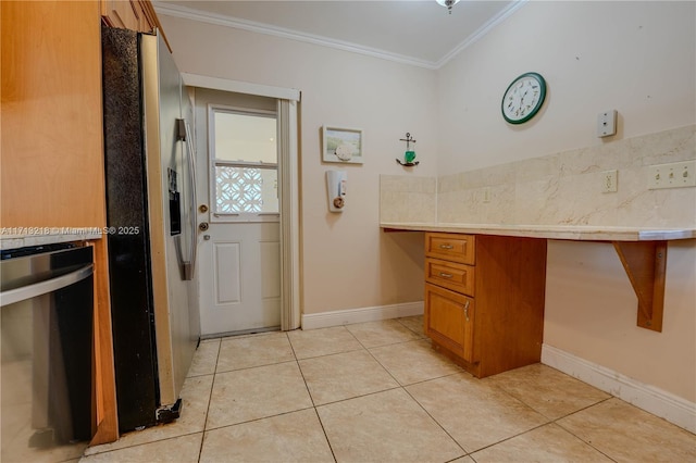 kitchen with built in desk, light tile patterned floors, crown molding, and stainless steel fridge