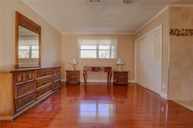 sitting room with hardwood / wood-style flooring, ornamental molding, and a textured ceiling