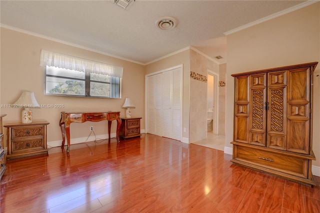 bedroom featuring a textured ceiling, a closet, crown molding, and wood-type flooring