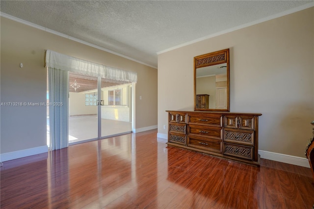 interior space with hardwood / wood-style flooring, access to exterior, a textured ceiling, and ornamental molding