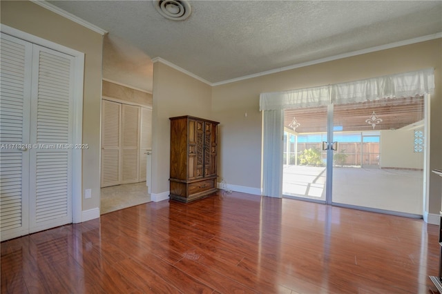 interior space with crown molding, a textured ceiling, and hardwood / wood-style flooring