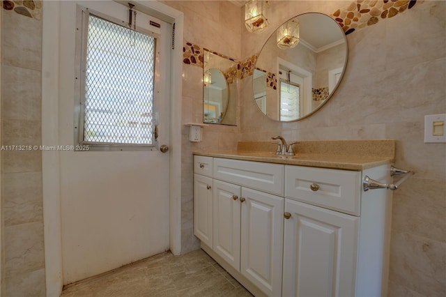 bathroom featuring tile walls, vanity, crown molding, and a healthy amount of sunlight