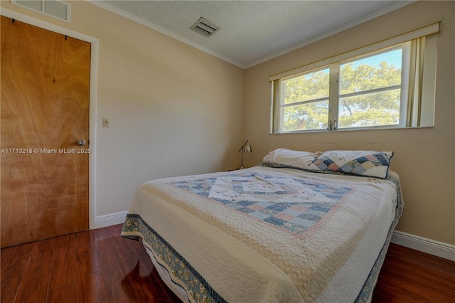 bedroom with dark hardwood / wood-style floors and ornamental molding