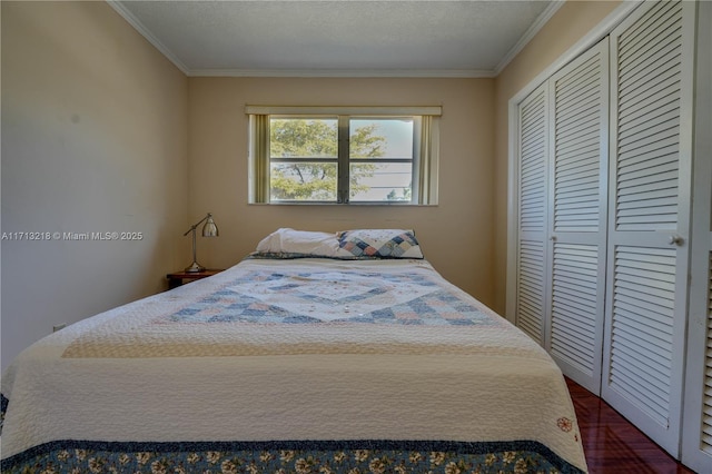 bedroom featuring a textured ceiling, a closet, and ornamental molding