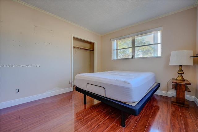 bedroom featuring a closet, crown molding, a textured ceiling, and hardwood / wood-style flooring