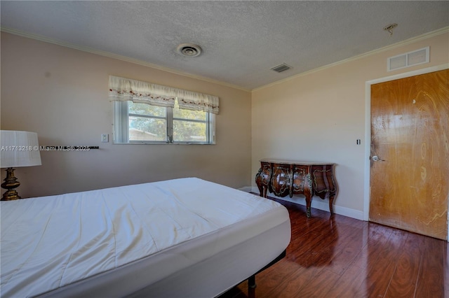 bedroom with dark wood-type flooring, a textured ceiling, and ornamental molding