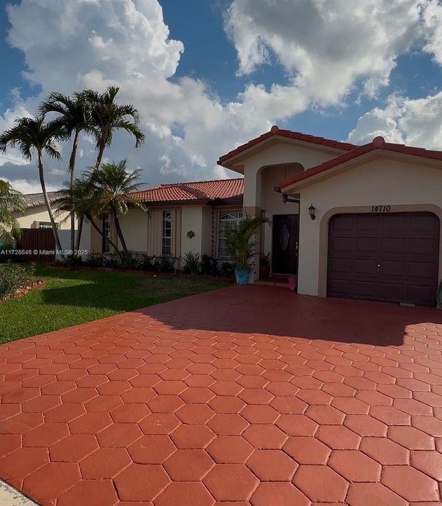 mediterranean / spanish home with a garage and a front yard