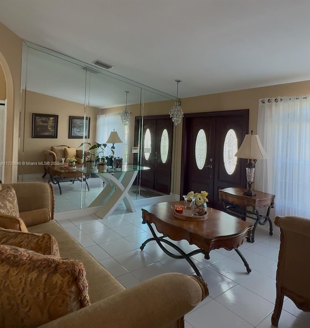 tiled living room featuring lofted ceiling and french doors