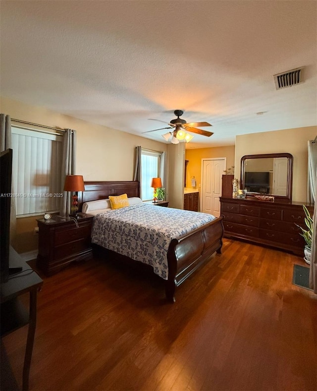 bedroom with ceiling fan, dark wood-type flooring, and a textured ceiling