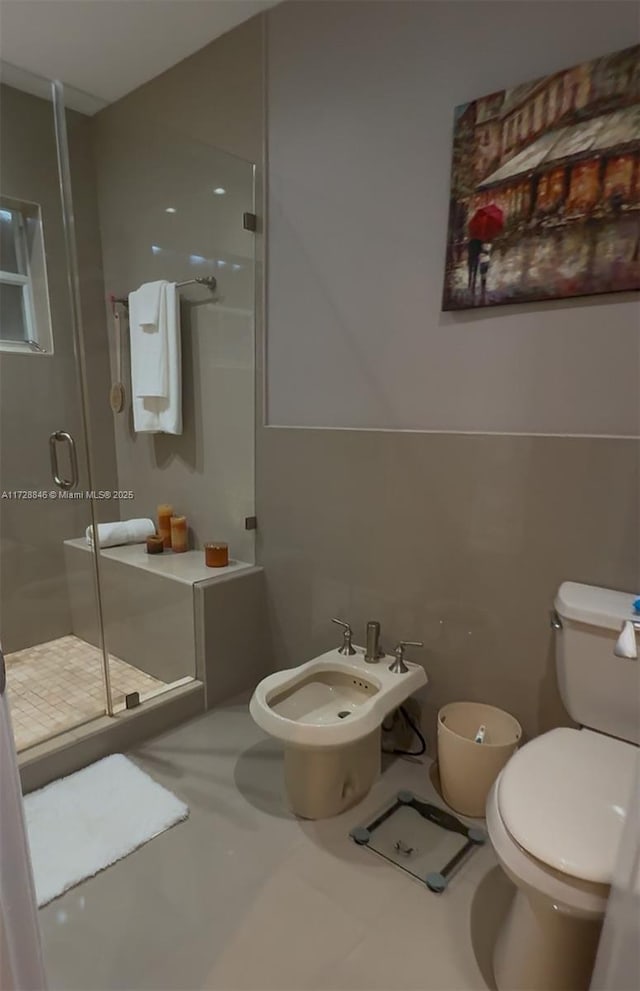 bathroom featuring a bidet, toilet, and a shower with door