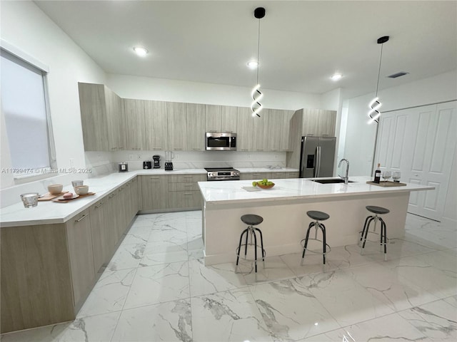 kitchen featuring hanging light fixtures, appliances with stainless steel finishes, and a center island