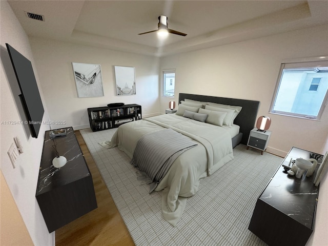 bedroom featuring ceiling fan and a raised ceiling