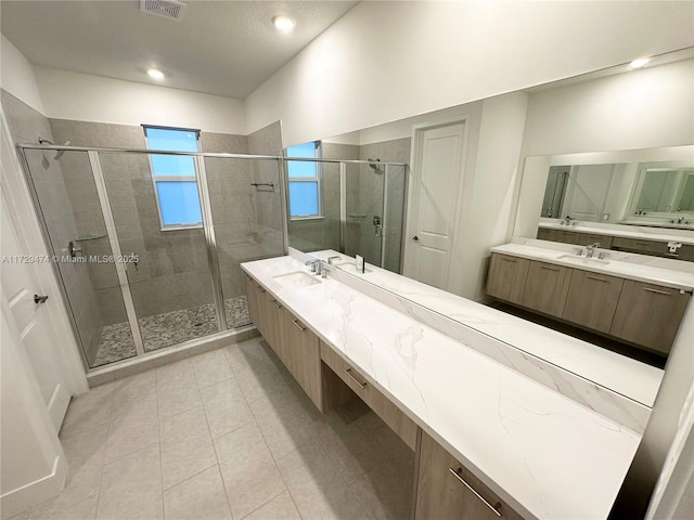 bathroom featuring a shower with shower door and vanity