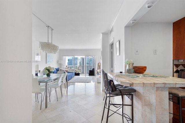 300 Bayview Dr Unit 1503, Sunny Isles Beach, FL 33160 - kitchen featuring open floor plan, a kitchen bar, tile countertops, and light tile patterned floors