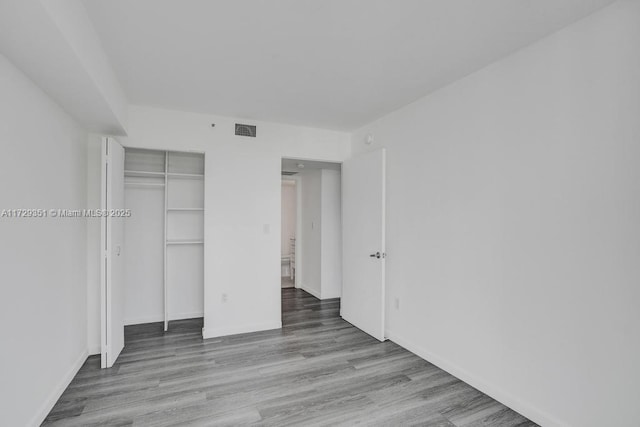 unfurnished bedroom featuring a closet and light wood-type flooring