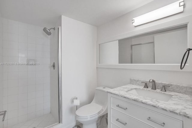 bathroom featuring vanity, toilet, and a tile shower