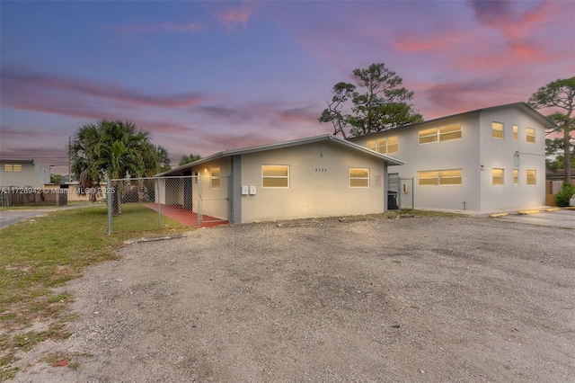 property exterior at dusk featuring a yard