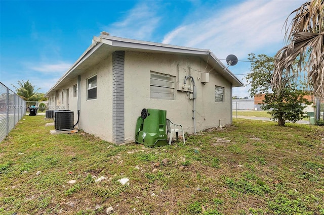 rear view of house with a lawn and cooling unit