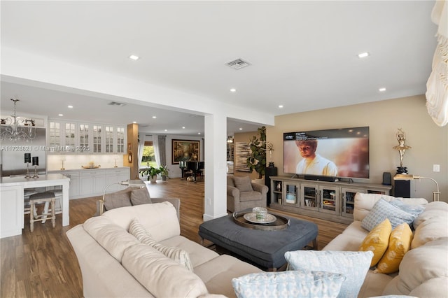 living room with dark hardwood / wood-style flooring and an inviting chandelier