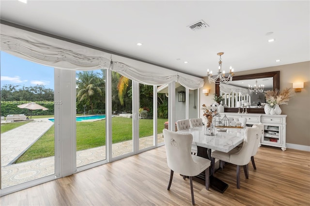 dining space with a notable chandelier and light hardwood / wood-style flooring