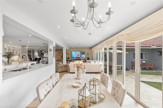 dining room with a notable chandelier, light hardwood / wood-style floors, and sink