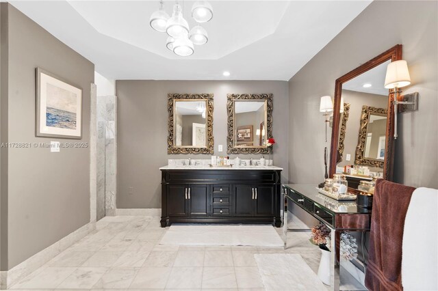 bathroom featuring vanity, a tray ceiling, and an inviting chandelier