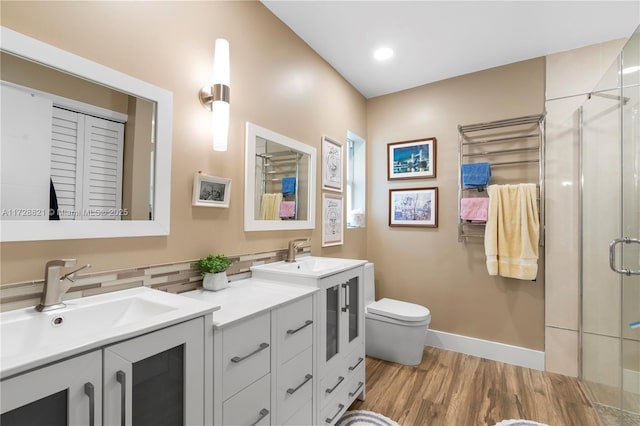 bathroom featuring vanity, hardwood / wood-style flooring, a shower with door, and toilet