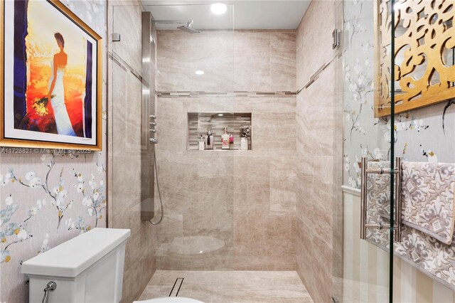 bathroom featuring toilet and a tile shower