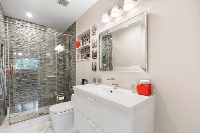 bathroom featuring vanity, an enclosed shower, tile patterned floors, and toilet