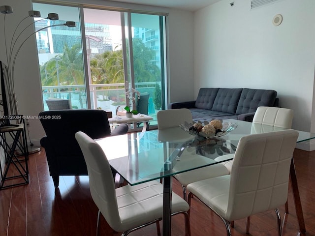 dining space with dark hardwood / wood-style flooring and expansive windows