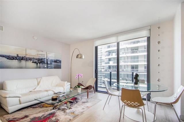 living room with floor to ceiling windows and light wood-type flooring