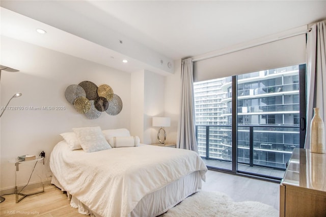 bedroom featuring access to exterior, light hardwood / wood-style floors, and multiple windows