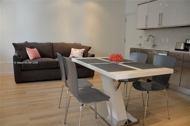 dining space with sink and light hardwood / wood-style flooring