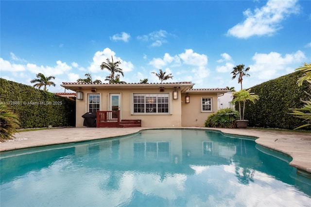 view of pool featuring area for grilling, an outdoor structure, and a patio area