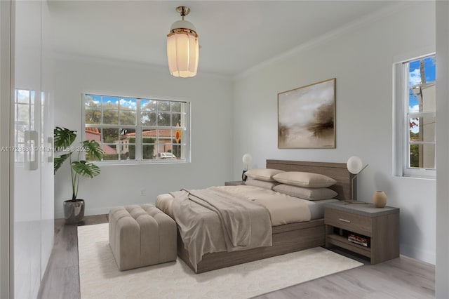 bedroom featuring ornamental molding and light hardwood / wood-style flooring