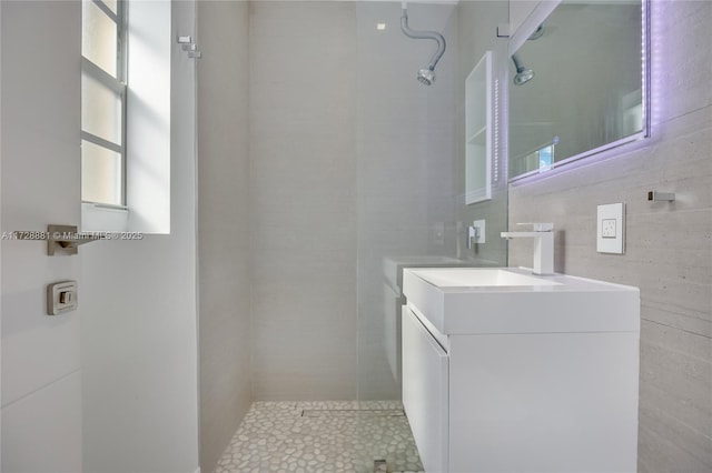 bathroom featuring vanity, tile walls, and a tile shower