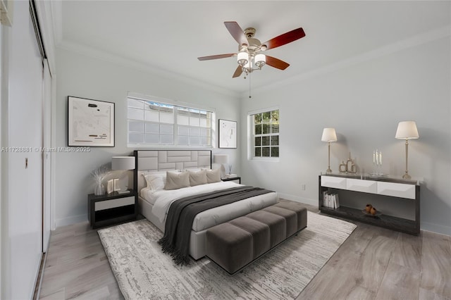 bedroom featuring ornamental molding, ceiling fan, and light wood-type flooring